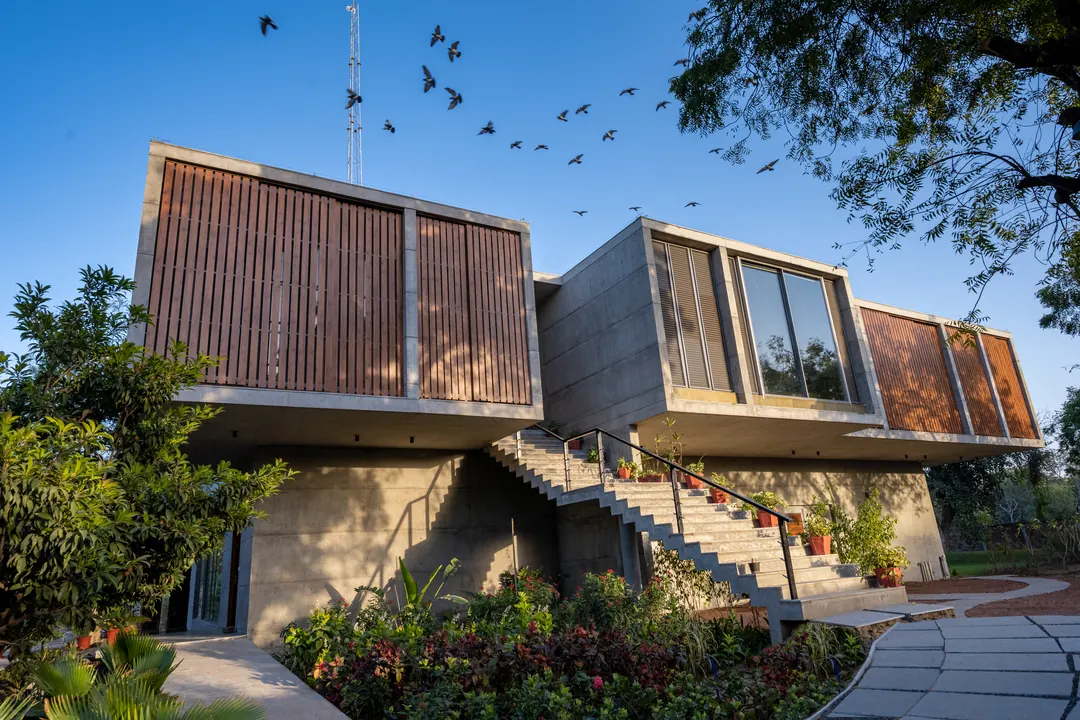 Stacked concrete volumes among trees, seen from the garden.